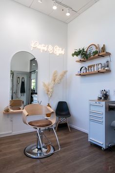 a hair salon with chairs, mirrors and shelves on the wall above it's mirror