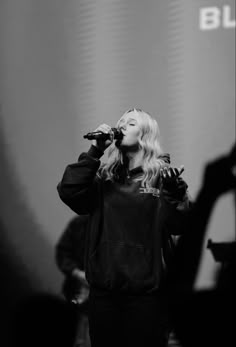 a woman singing into a microphone on stage