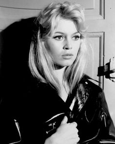 a black and white photo of a woman wearing a leather jacket