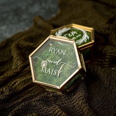 two small boxes with the words ryan and maisy on them sitting on a blanket