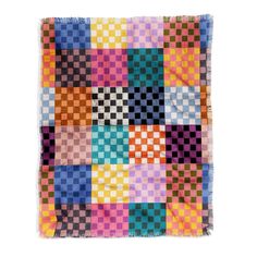 a multicolored patchwork quilt hanging on a white wall in front of a white background