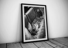 a black and white photo of a leopard laying down on a couch in a room