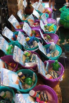 several buckets filled with candy sitting on top of a table next to each other