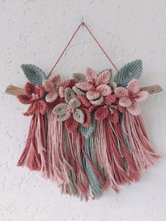 a wall hanging with flowers and leaves on it