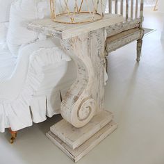 a white couch sitting next to a wooden table with a crown on top of it