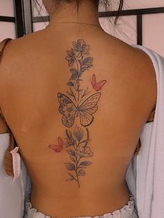 the back of a woman's body with butterflies on her back and flowers growing out of it