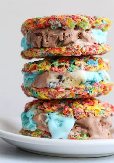 a stack of ice cream and sprinkle cookies on a white plate with chocolate frosting