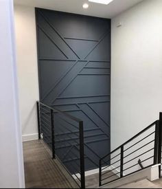 an empty room with some stairs and a wall painted in dark blue color, next to a set of black handrails