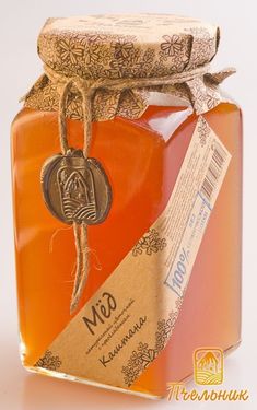 a glass jar filled with honey sitting on top of a table