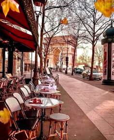 tables and chairs are lined up on the sidewalk