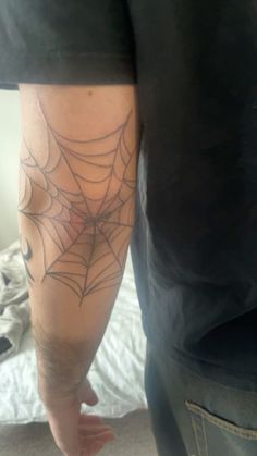 a man with a spider web tattoo on his arm