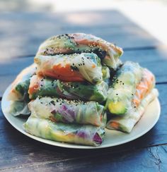 a white plate topped with vegetable rolls covered in seasoning and sprinkles