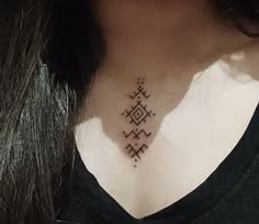 a woman's neck with a tattoo on it that has an arrow in the middle