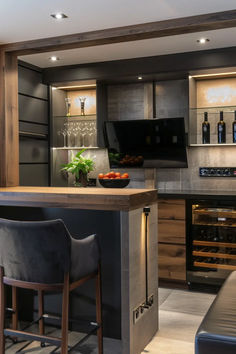 a kitchen with two bar stools next to an oven and wine bottle on the counter