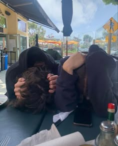 a person laying on top of a table with an umbrella over their head