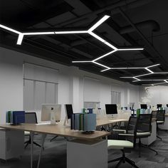 an empty office with desks and computers on the tables in front of them,