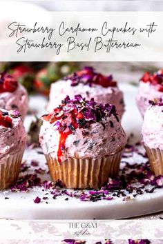 strawberry cupcakes with strawberry frosting and sprinkles on a plate