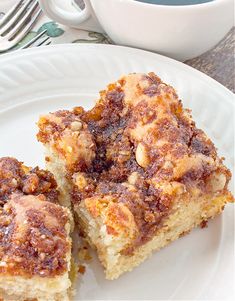 two pieces of cake on a plate next to a cup of coffee