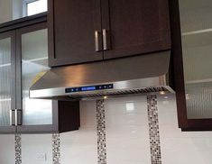 a stove top oven sitting inside of a kitchen next to wooden cabinets and drawers on the wall