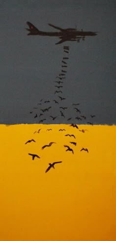 a flock of birds flying over a yellow field