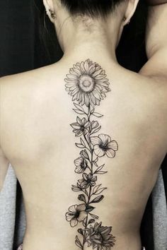 the back of a woman's neck with flowers on it