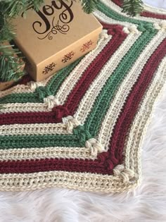 a crocheted christmas tree skirt with a box on it