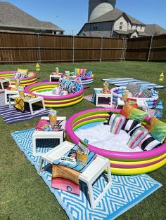 an inflatable pool is set up on the lawn with chairs and tables around it