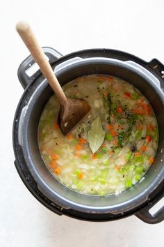 a wooden spoon in a pot filled with soup