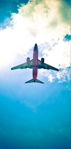 an airplane is flying in the sky on a clear day with sun shining through clouds