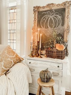 a bedroom decorated with pumpkins, candles and an old chalkboard in the corner