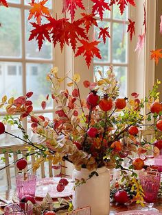 a vase filled with flowers sitting on top of a table next to plates and glasses