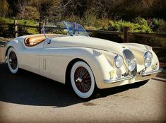 an old white car is parked on the street