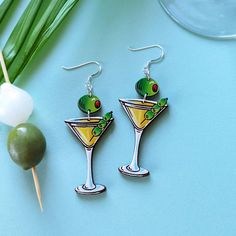 These retro dirty martini cocktail earrings are the perfect companion for parties, holidays, or everyday! These original earrings are hand painted and etched on cherry wood and feature precision-painted elements like the classic martini olive garnish. Lightweight and cute, these cocktail dangles are a fun addition to your wardrobe and a great gift for your favorite martini connoisseur! This is a one-of-a-kind set you can't get anywhere else! Option #1: Gold Ear WiresThese earrings feature gold hypoallergenic 304 stainless steel ear wires. Option #2: Silver Ear WiresThese earrings feature silver hypoallergenic 304 stainless steel ear wires. Option #2: Sterling Silver Ear WiresThese earrings feature hypoallergenic .925 solid sterling silver ear wires and jump rings. Martini Olive, Martini Olives, Classic Martini, Cocktail Earrings, Dirty Martini, Martini Cocktail, Gift Card Shop, Cherry Wood, Jump Rings