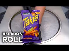 a bag of food sitting on top of a metal pan with someone's hand holding it