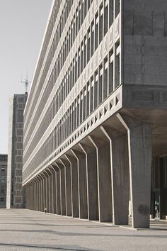 a man riding a skateboard down the middle of a street next to a tall building