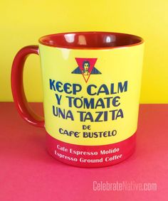 a yellow and red coffee mug sitting on top of a pink table next to a yellow wall