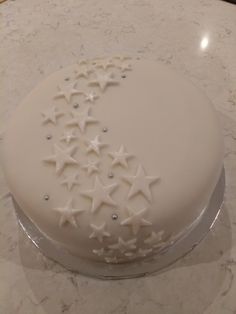 a white cake with stars on it sitting on a marble counter top in the shape of a crescent