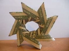 an origami star made out of dollar bills on a wooden table with white background