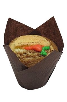 a muffin in a brown wrapper with carrots on top