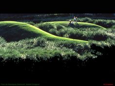 two people are walking in the middle of a grassy area that looks like mounds with grass growing on them