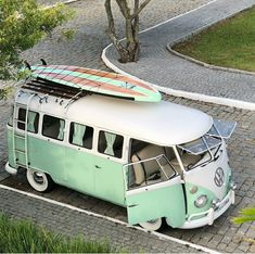 an old vw bus with a surfboard on top is parked in the street