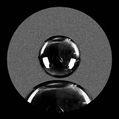 two glass balls sitting on top of a black and white circle with one in the middle