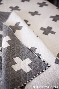 three quilts on top of each other with black and white designs in the middle