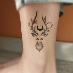 a tattoo on the leg of a woman with deer's head and antlers