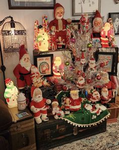 a christmas tree is surrounded by santa clause figurines and other holiday decor items