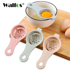 an egg slicer and other kitchen utensils on a cutting board with eggs in the background