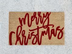 a door mat with the words merry christmas written in red ink on top of it