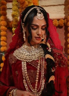 a woman dressed in red and gold is looking at her cell phone