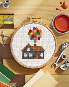 a cross stitch house with a hot air balloon