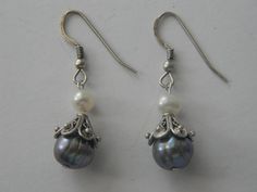 These elegant Victorian Style Genuine Gray & White Pearl Bridal Drop Hook Earrings are a beautiful addition to any jewelry collection. The intricate filigree cap design adds a touch of sophistication to these classic earrings. Perfect for any formal occasion, these earrings are sure to impress. Crafted with high-quality materials, these earrings are durable and long-lasting. The genuine gray and white pearls are a timeless combination, making these earrings a great choice for any bride. These ea Elegant Silver Earrings With Bead Caps, Traditional Wedding Jewelry With Bead Caps, Cap White, Classic Earrings, Pearl Bridal, Wedding Jewelry Earrings, White Bridal, Classic Jewelry, Vintage Pearls